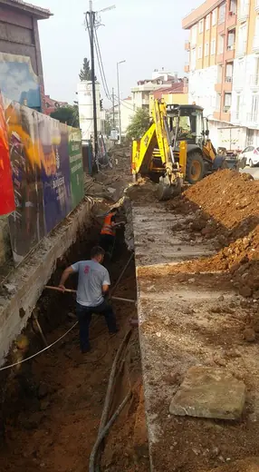 Duvar kenarında kazılmış kanalda altyapı çalışması